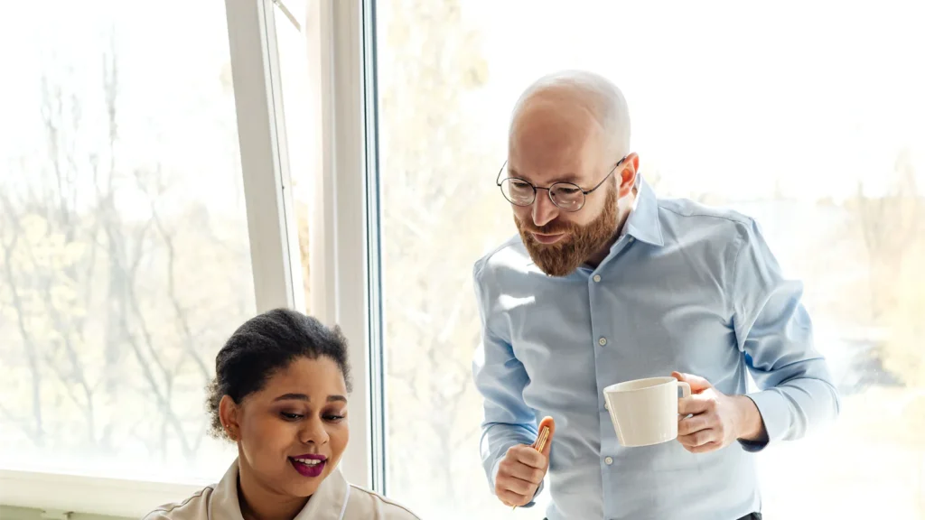 Adviser and colleague going through paperwork in a bright office