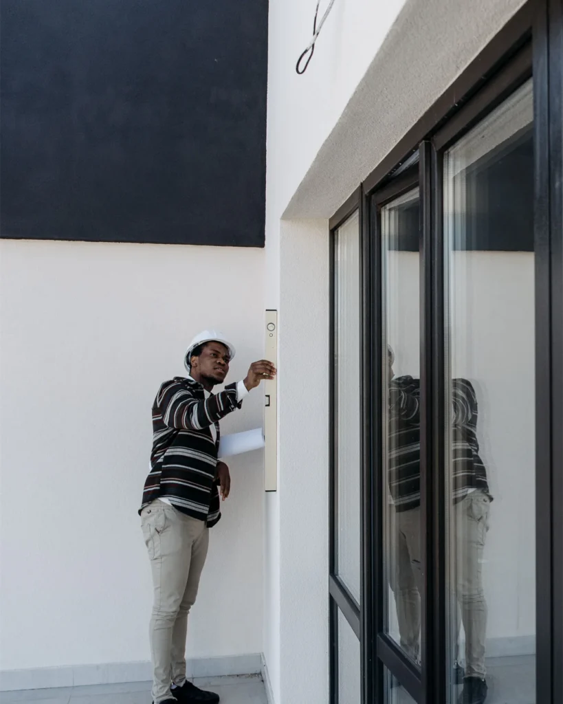 Person examining a wall and doorway during a property inspection