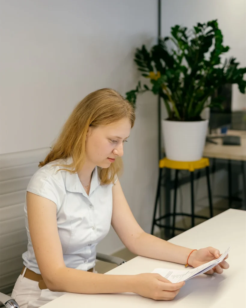 Lawyer reading a printed agreement at a desk in a bright office