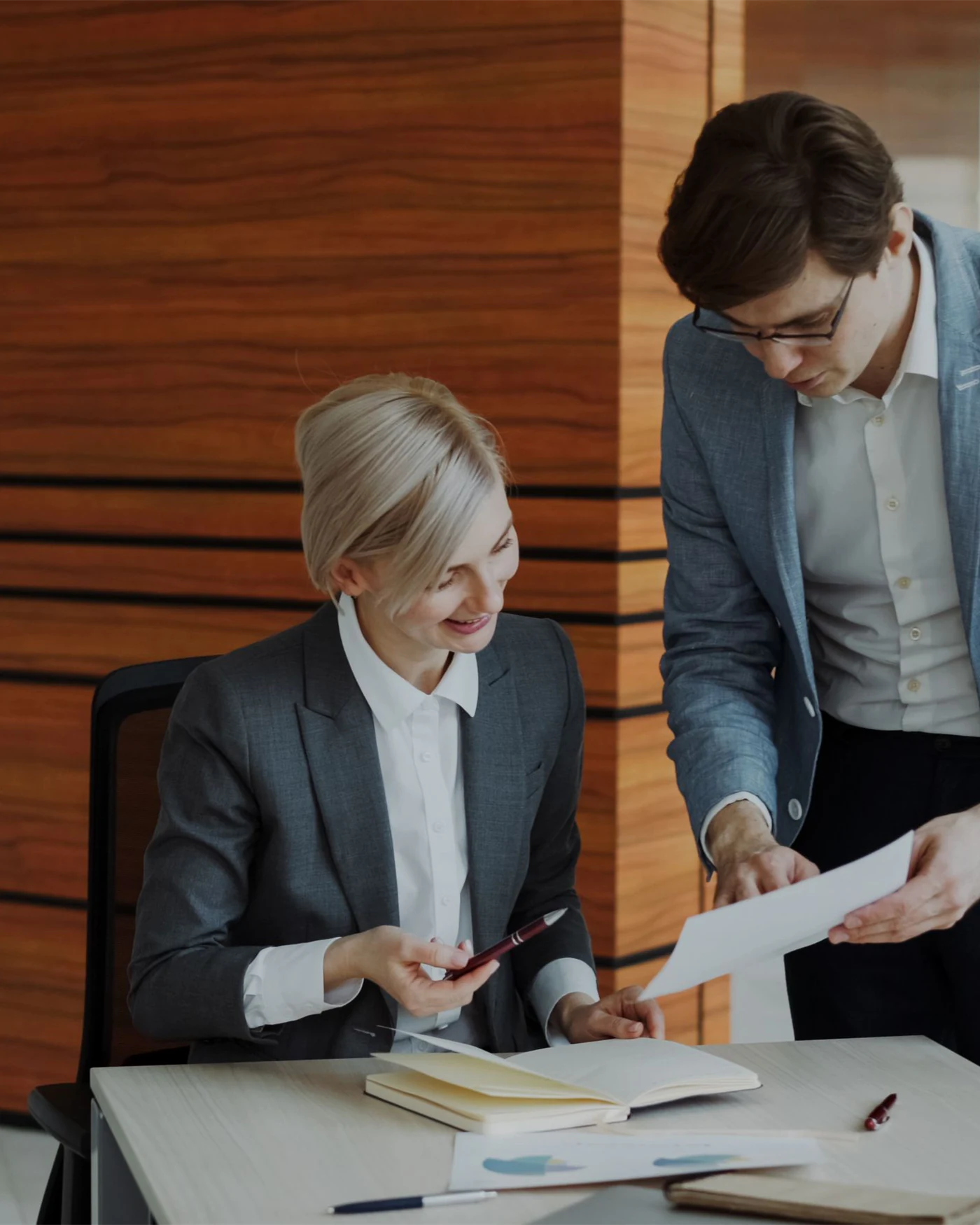 Adviser handing an employment contract to a colleague at an office desk