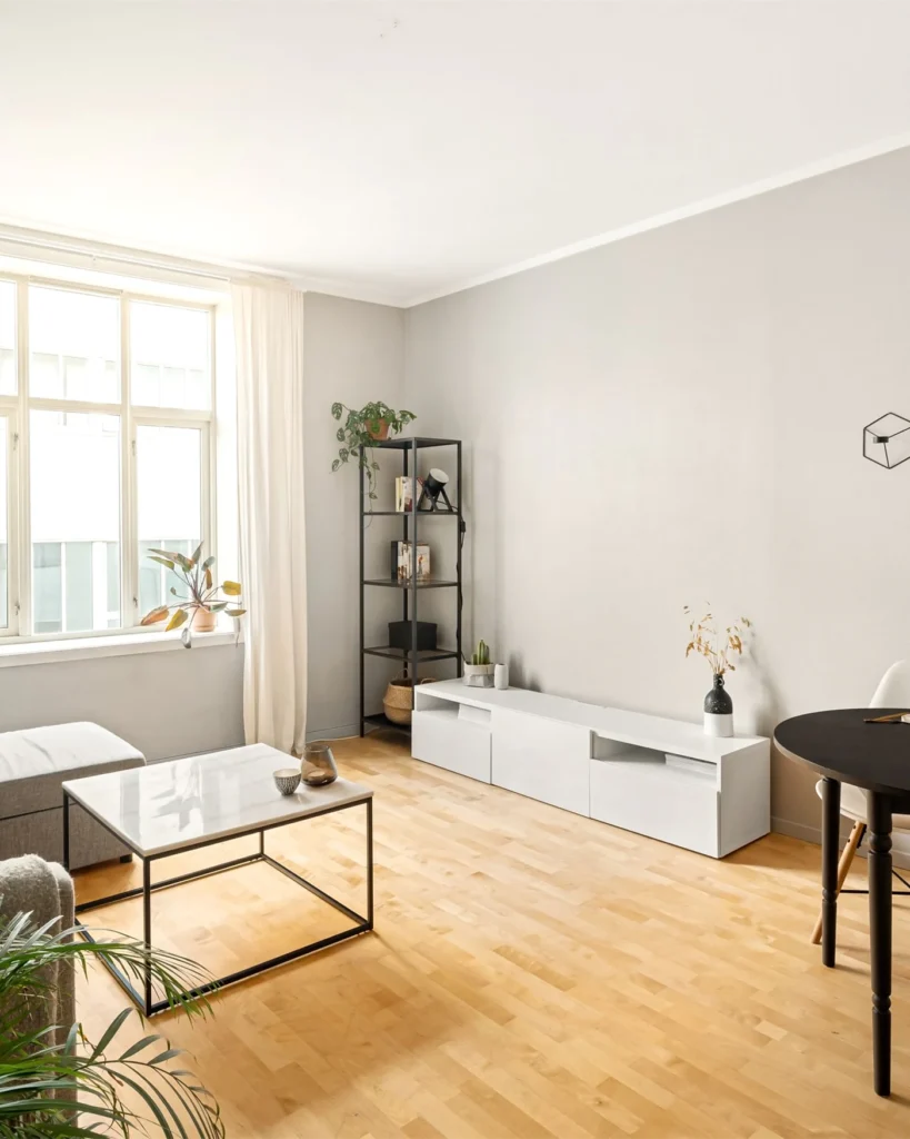 Bright Scandinavian apartment living room with wooden floor and a large window