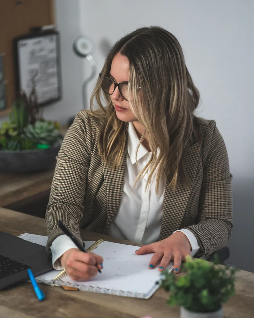 Lawyer taking notes while reviewing a client document at a desk