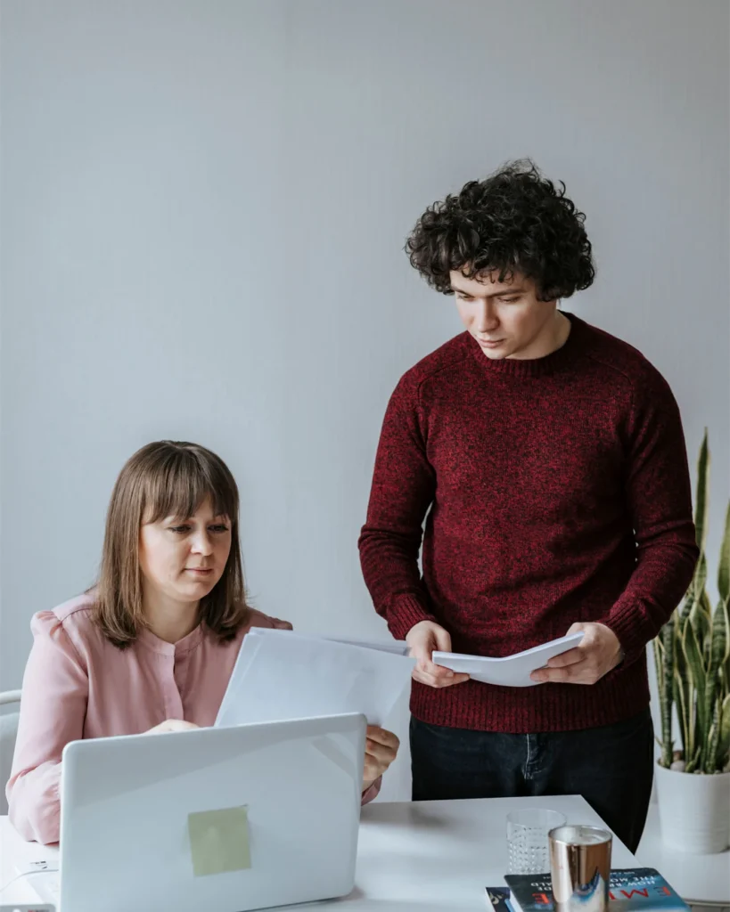 Two people going through transaction paperwork at a table