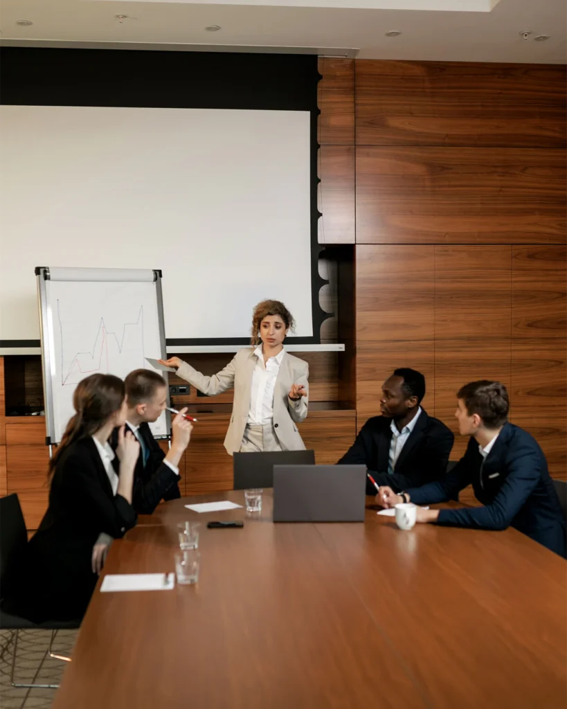 Board members seated around a table while a colleague presents