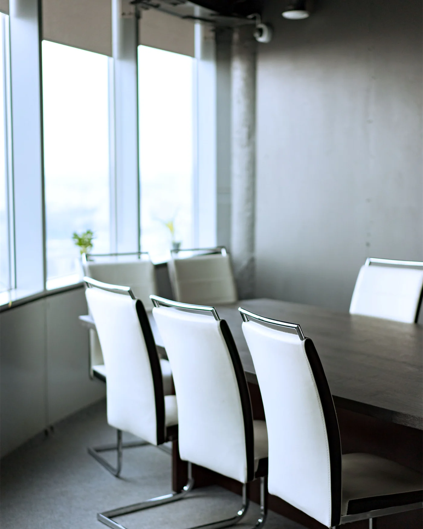 Empty boardroom with chairs beside a wall of windows