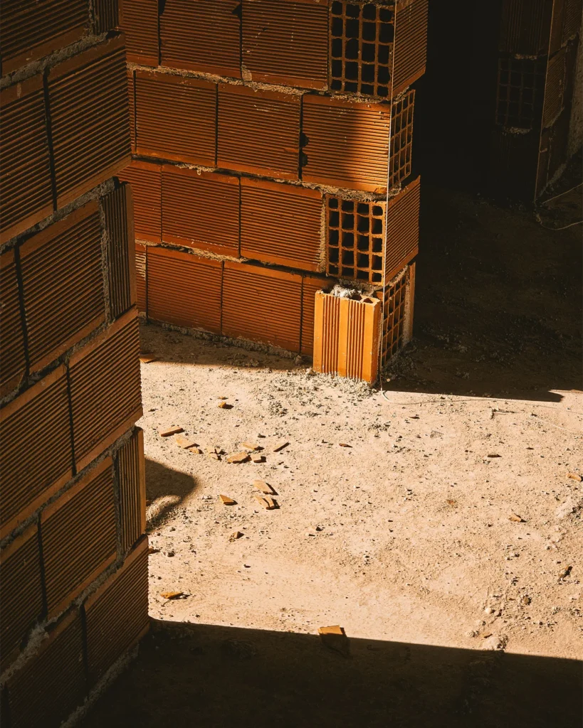 Stacked clay building blocks on a construction site floor
