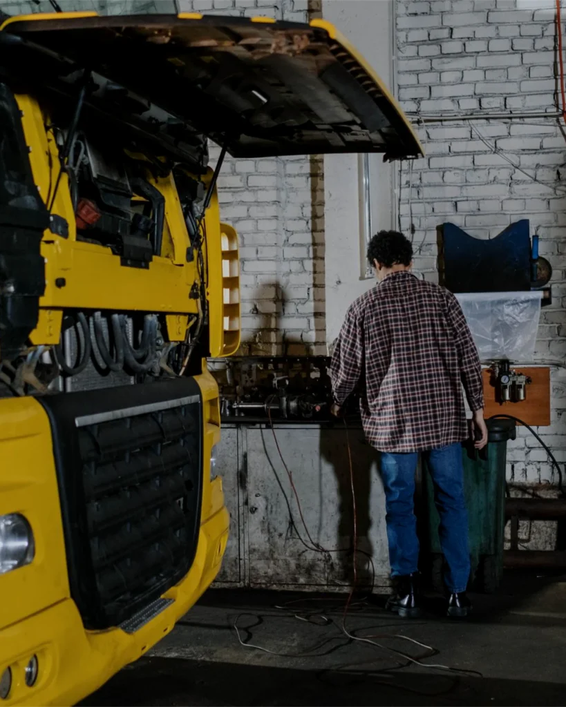 A lorry with its cab tilted forward for engine work in a workshop