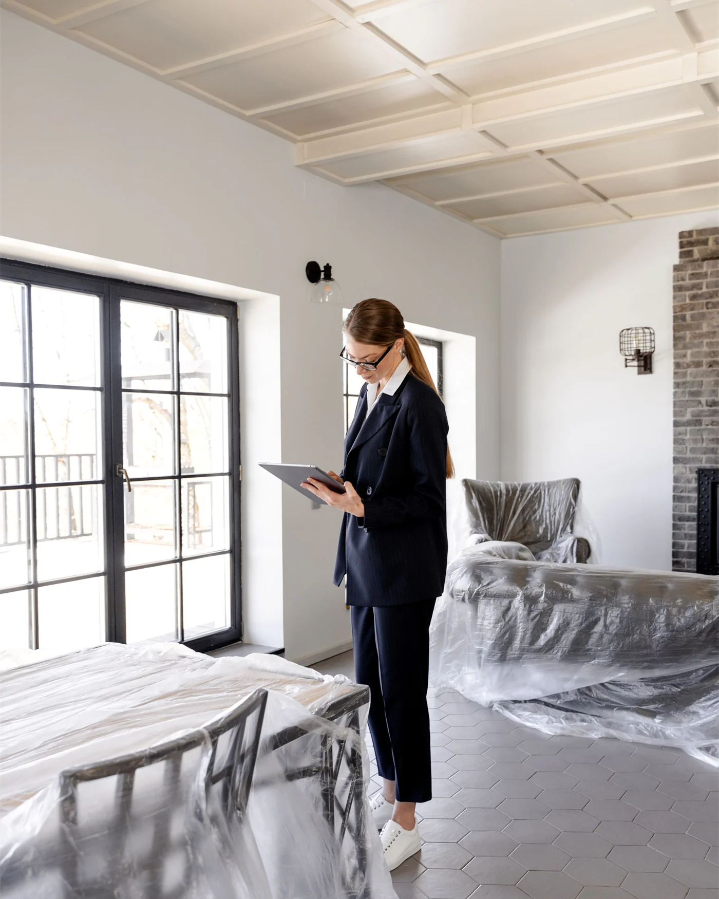 A surveyor assessing an empty property with furniture under dust sheets