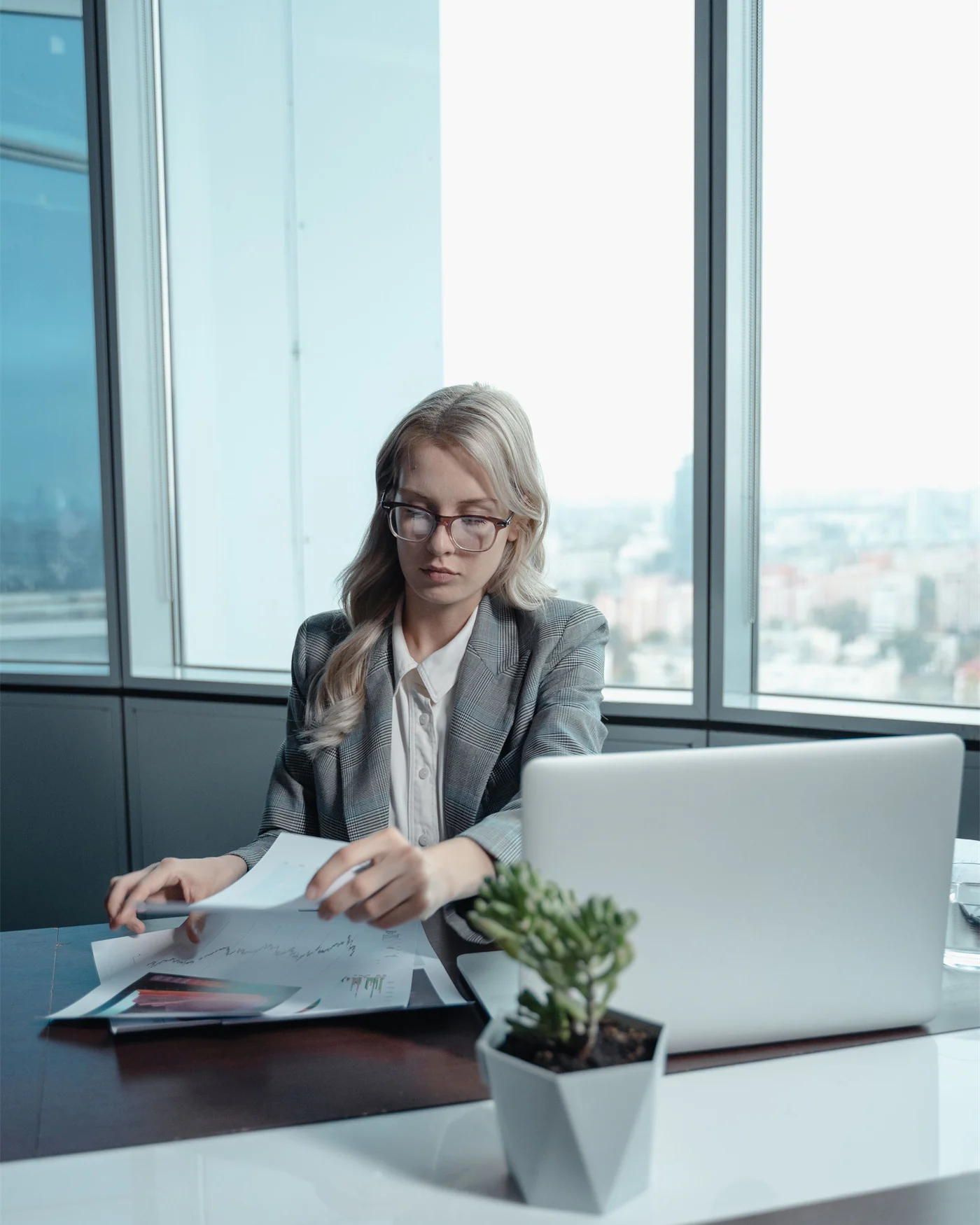Professional working through documents at a desk beside a window