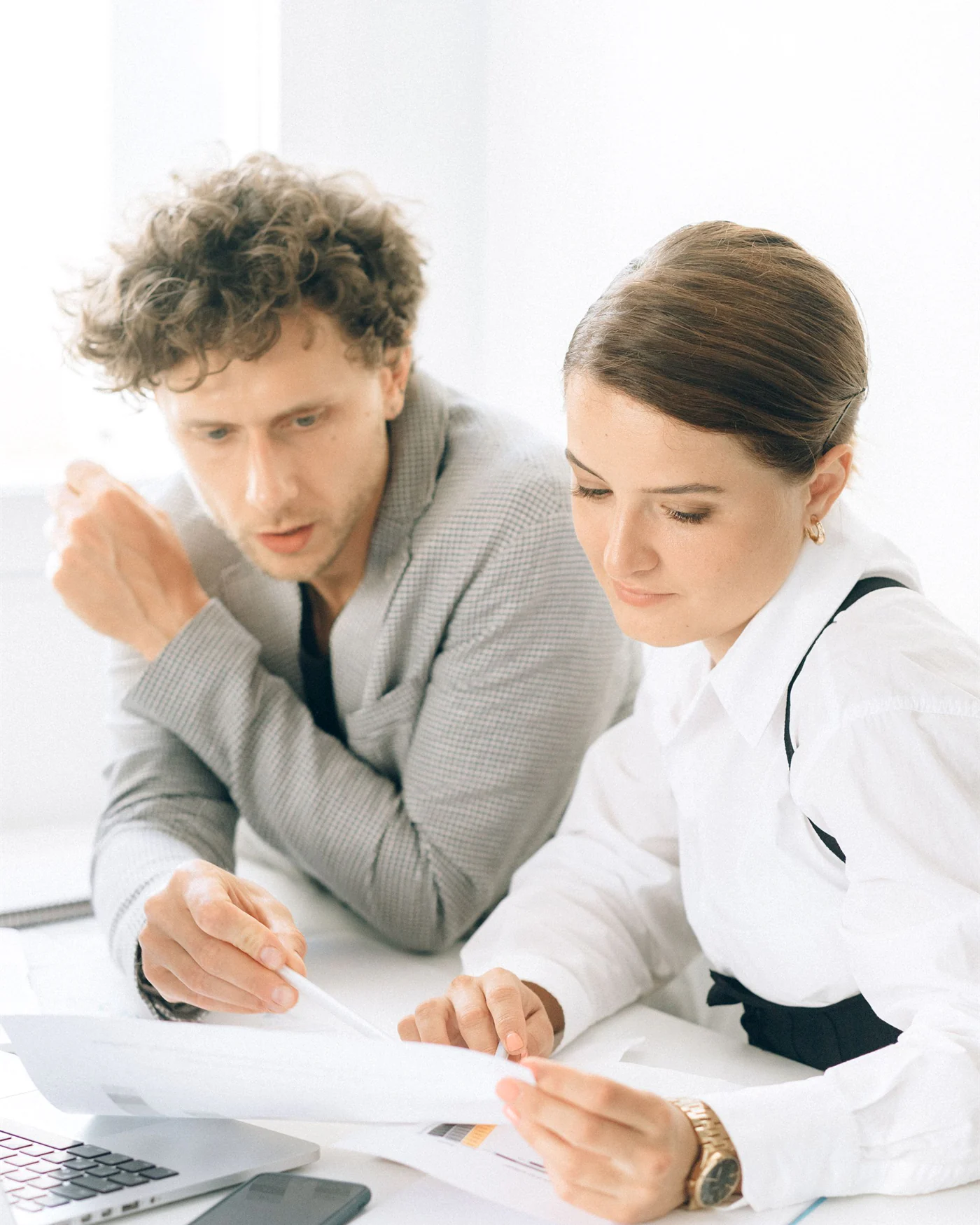 Two colleagues reviewing a printed document together in an office