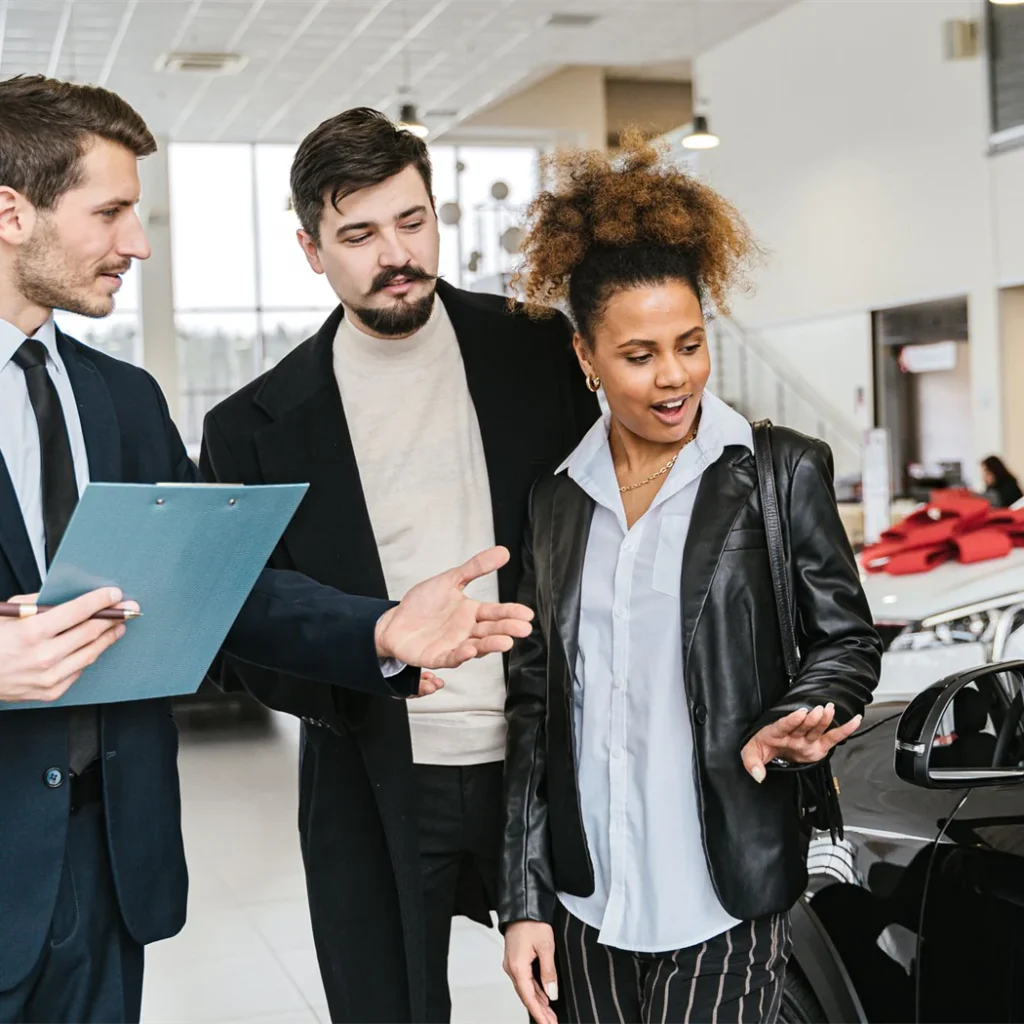 Three people discussing a case together at a car dealership