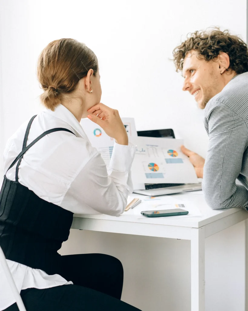 Two colleagues working through information together at a desk