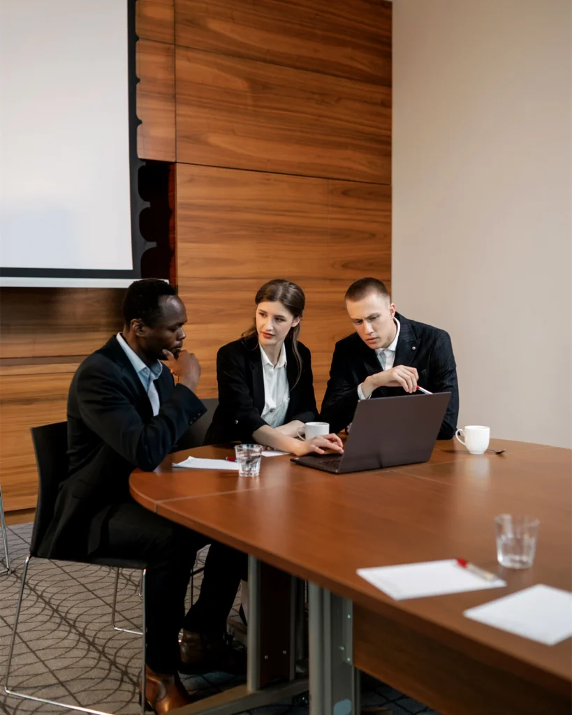 Three people seated around a conference table during a mediation