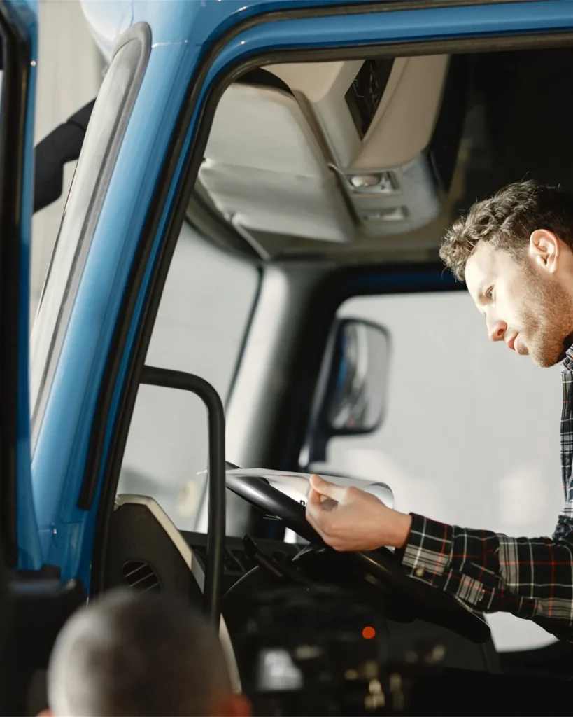 A driver recording a fault on a tablet in the cab of a lorry