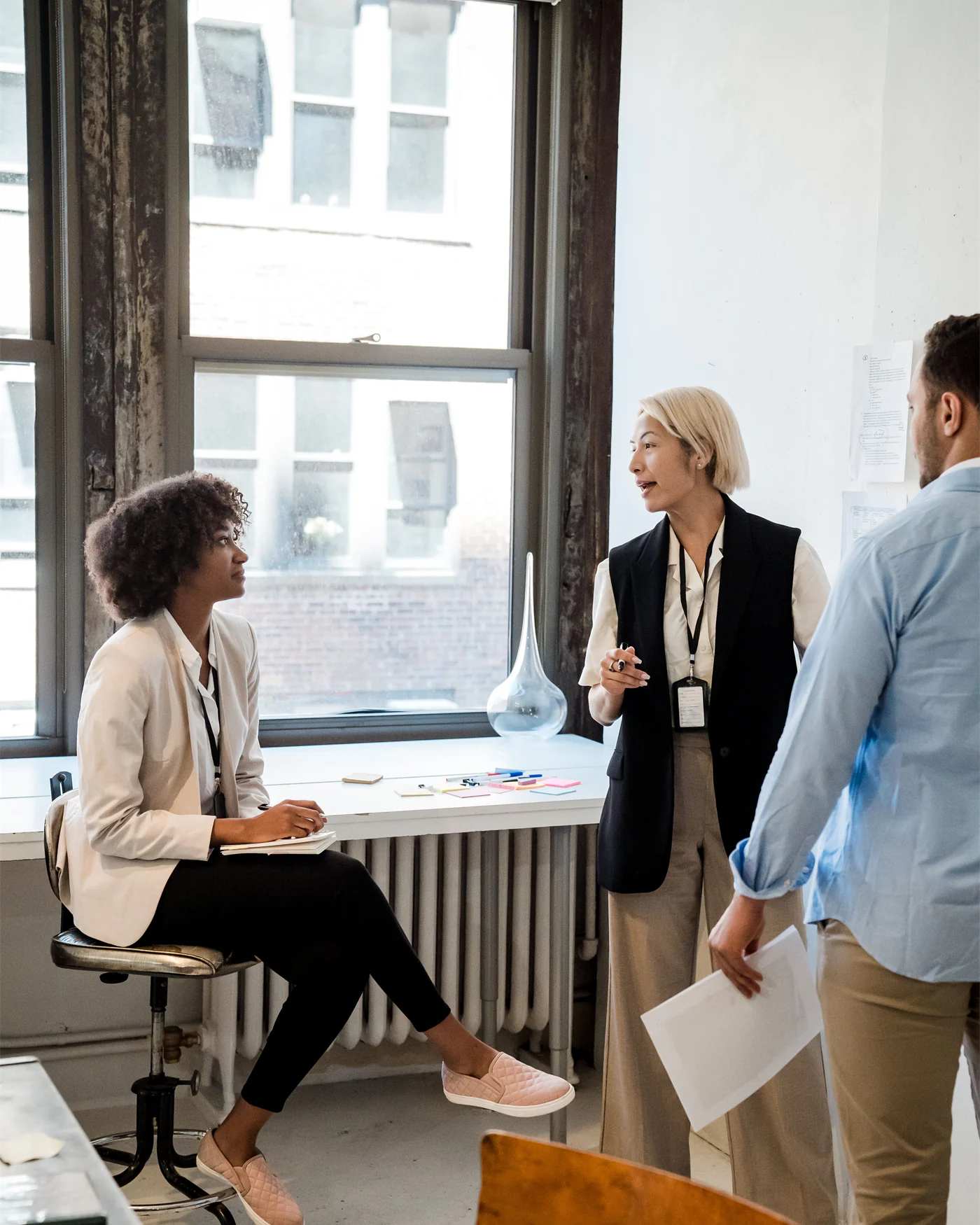 Colleagues discussing a case beside an office window
