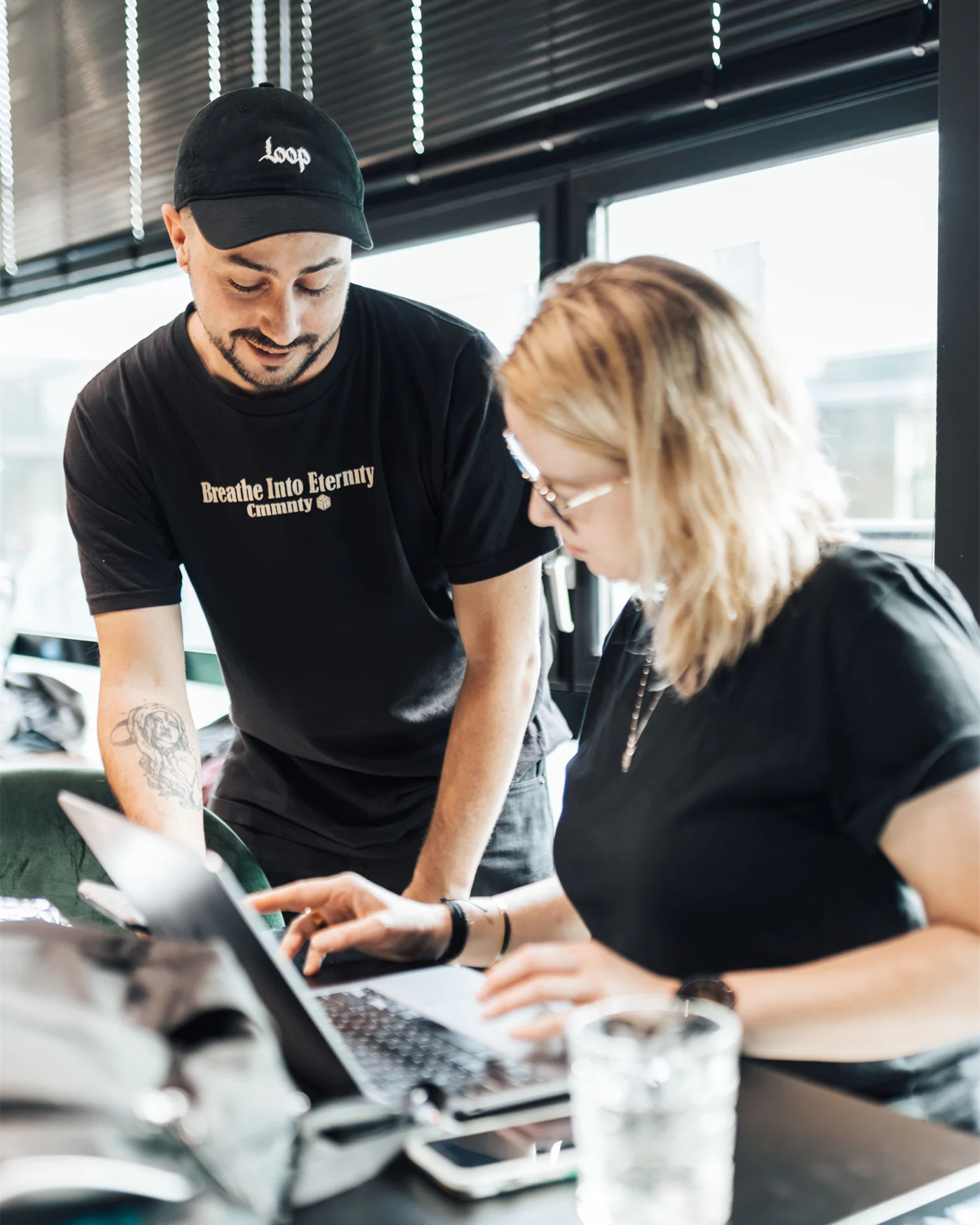 Two colleagues reviewing work together at a monitor