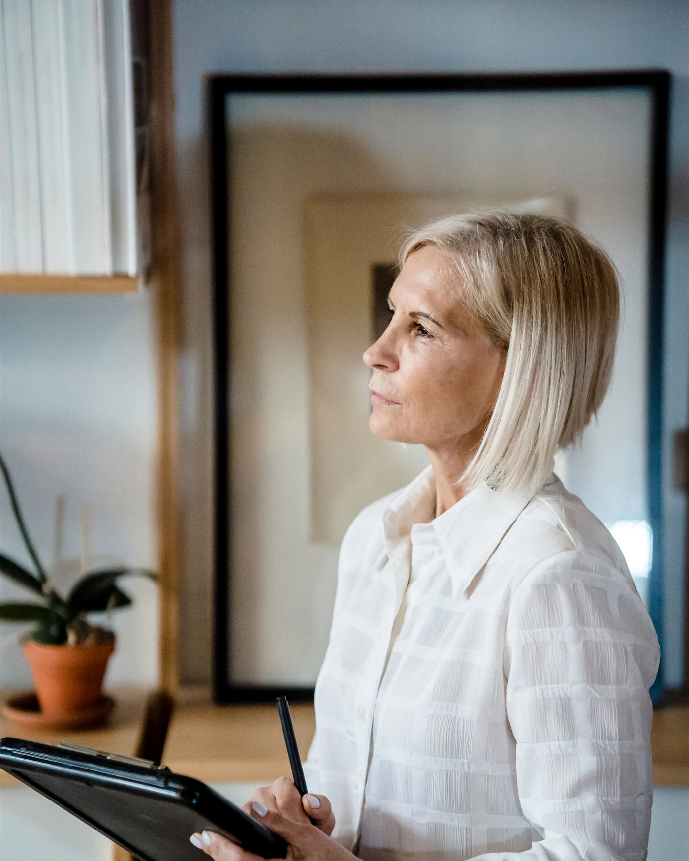 Adviser making notes on a clipboard in a bright office