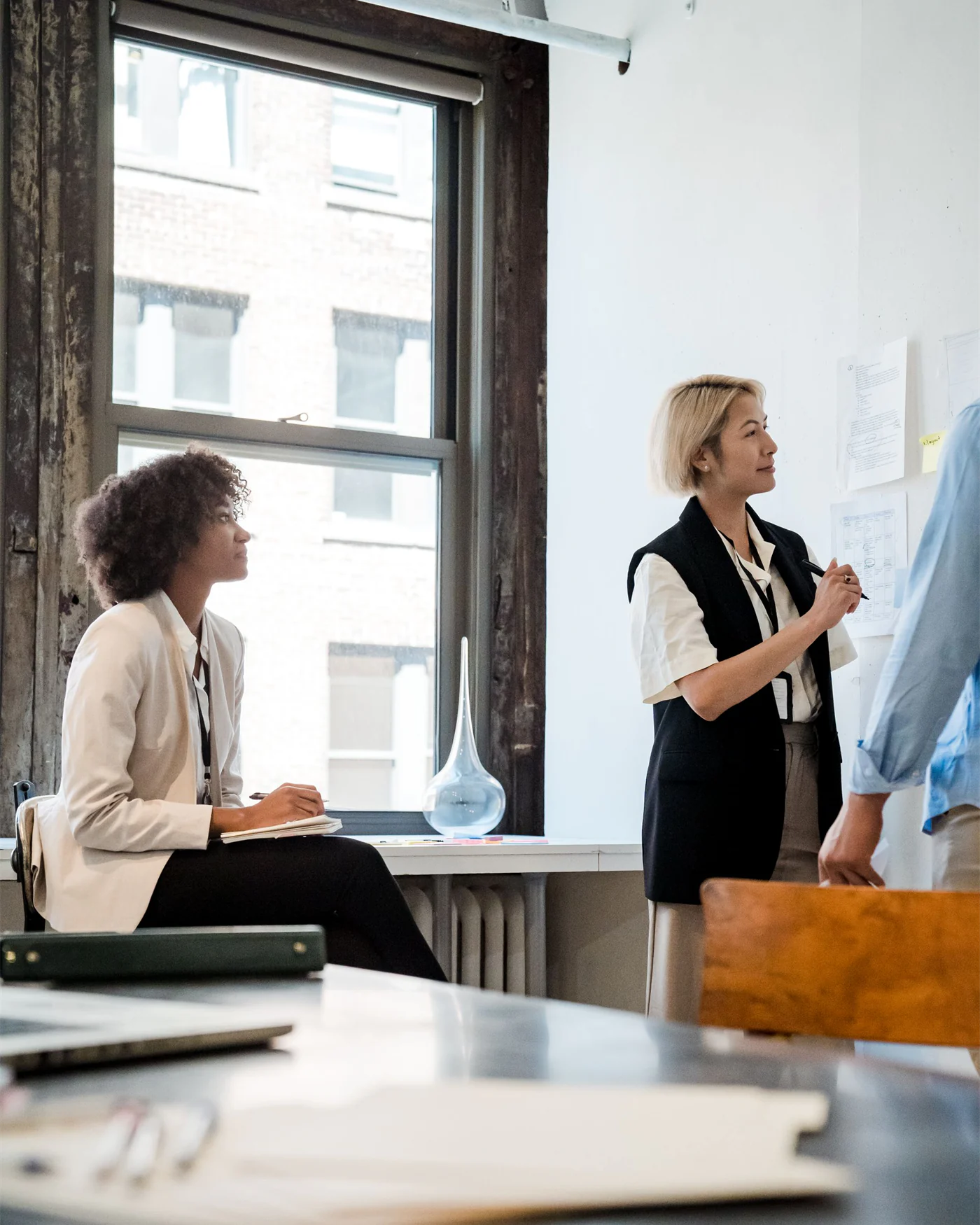 Two colleagues discussing a case beside an office window