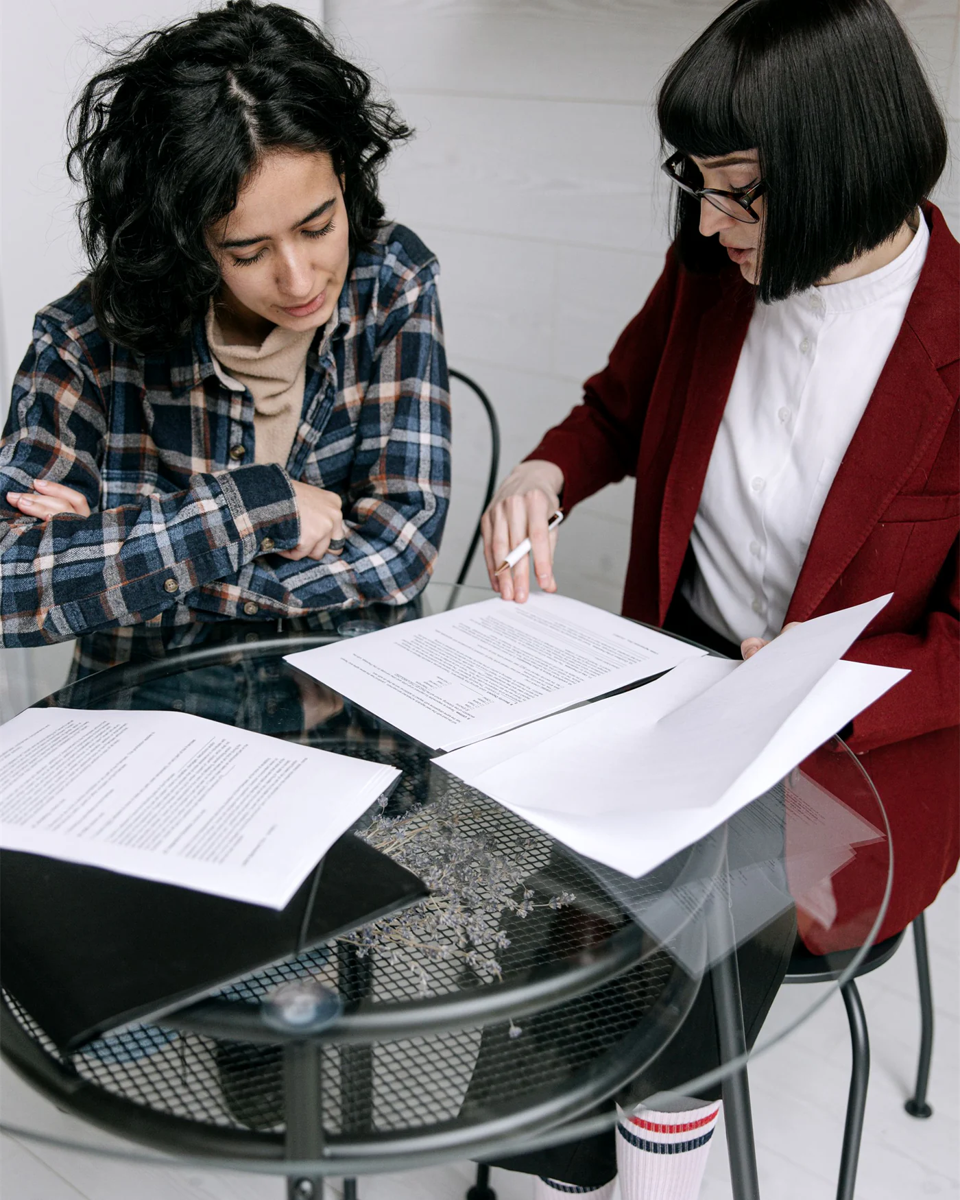 Two people working through application paperwork together at a table