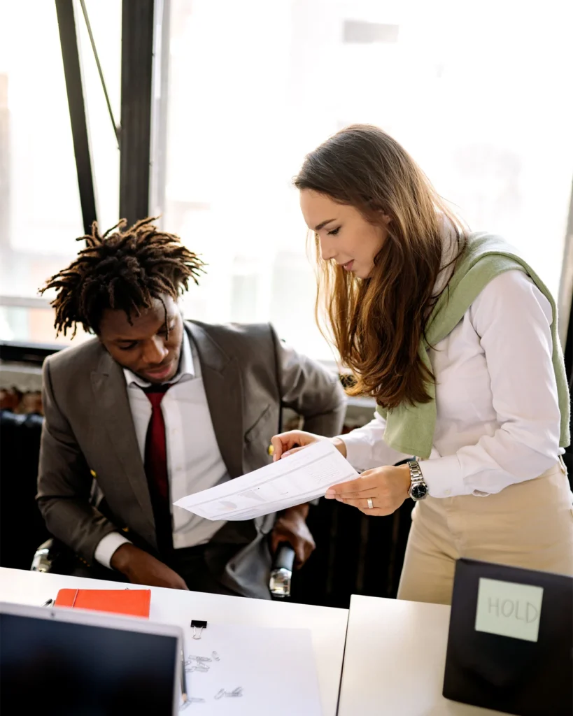 Two colleagues reviewing workplace policy documents at a desk