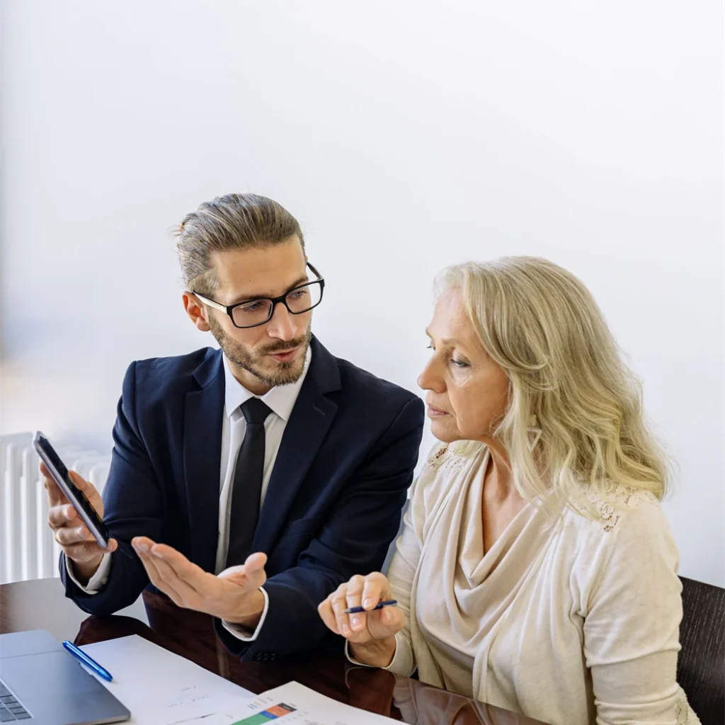 An adviser going through figures with a client at a meeting table