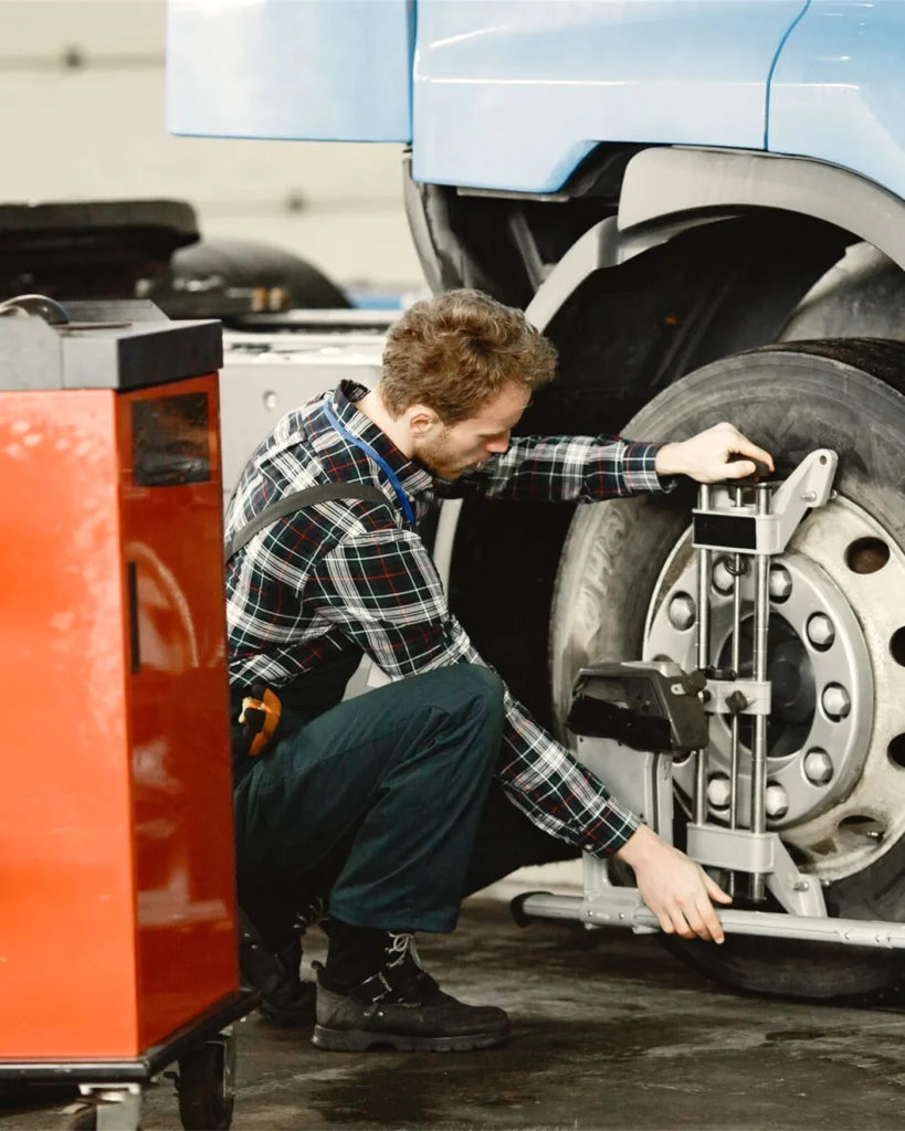 A technician repairing the wheel assembly of a heavy goods vehicle