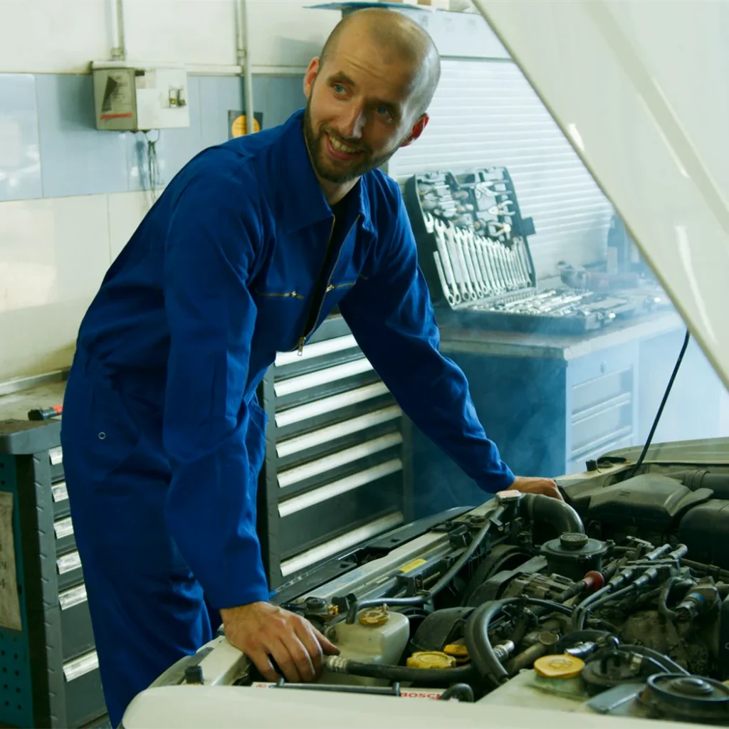 A mechanic carrying out repair work on a car engine