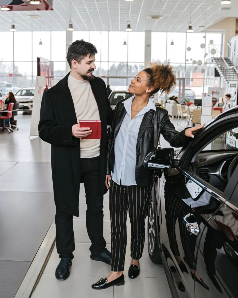 Buyers inspecting a car with a dealership representative