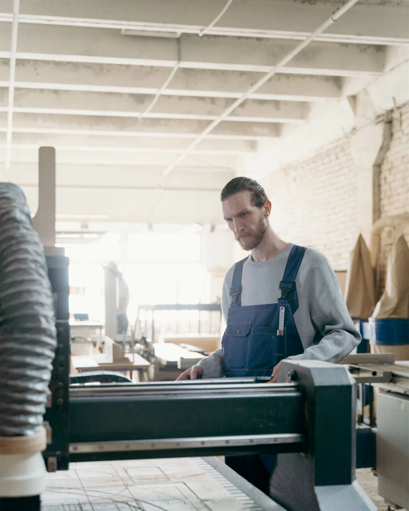 Machine operator at work beside equipment in a workshop