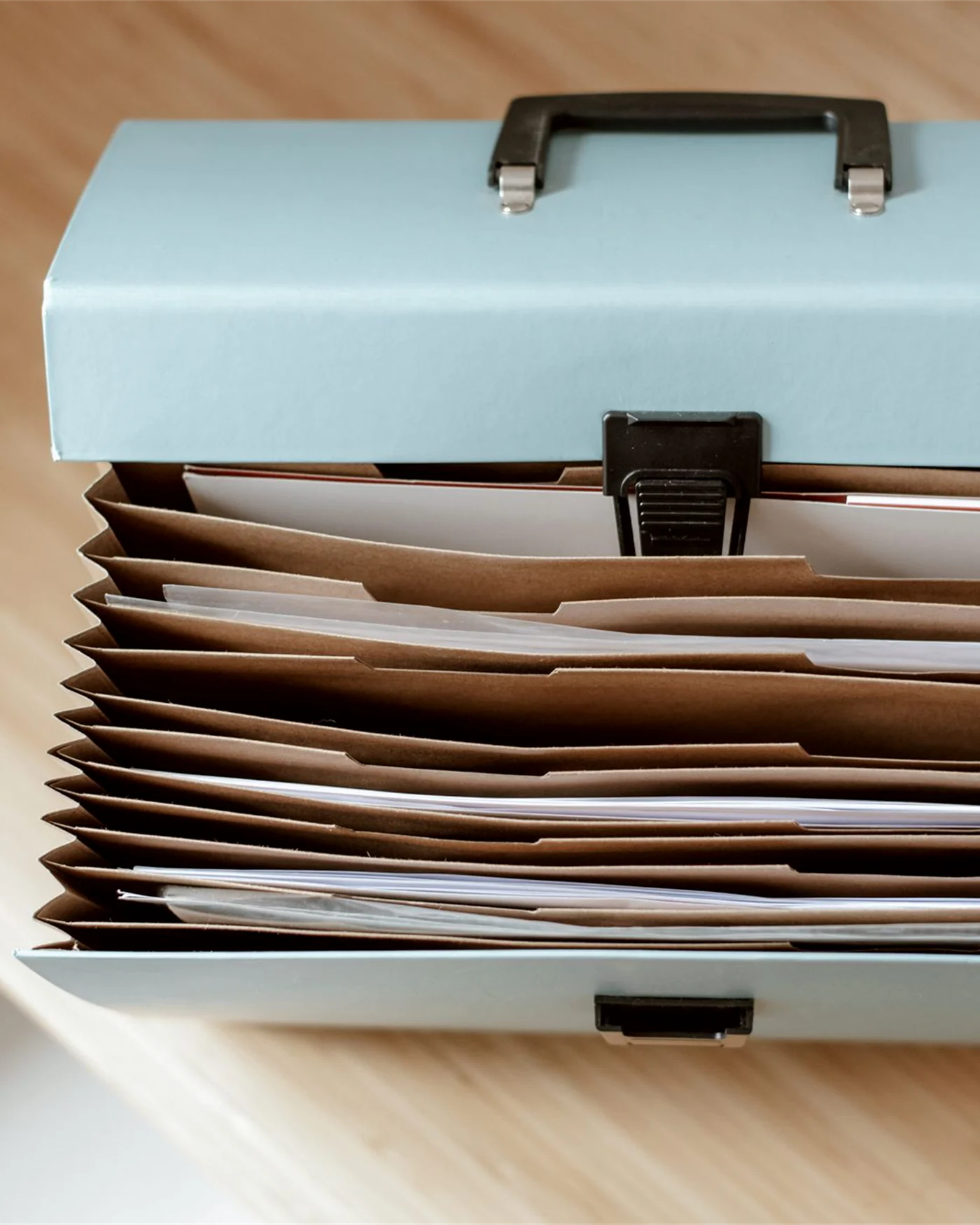 A document organiser holding sorted paperwork on a desk