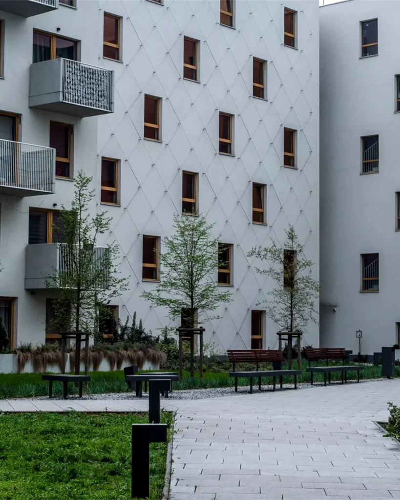 A contemporary Swedish apartment complex with a landscaped courtyard