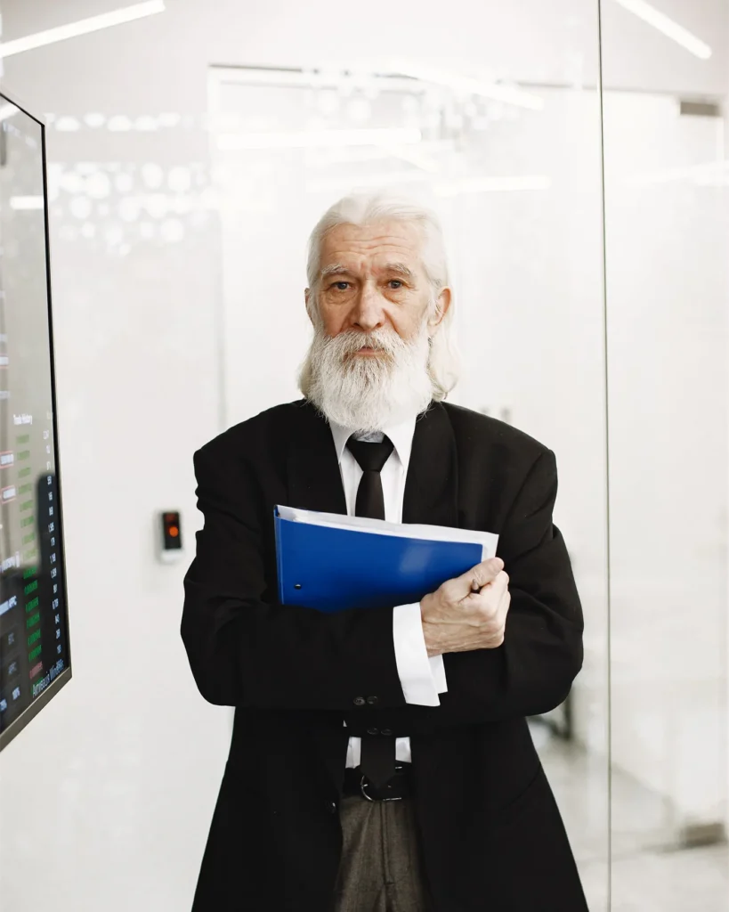 A senior executive holding a folder of documents in a modern office