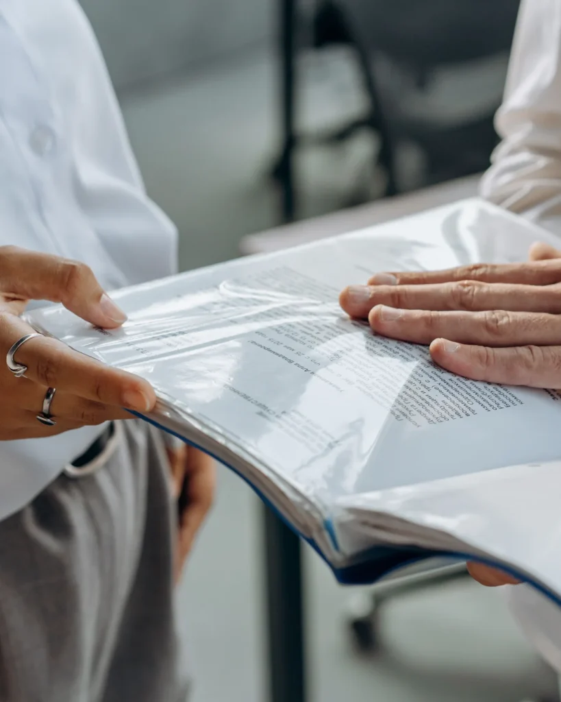 Two people reviewing papers in an open document folder