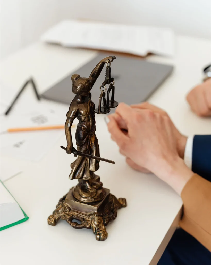 A figure of Justice holding scales on a lawyer desk