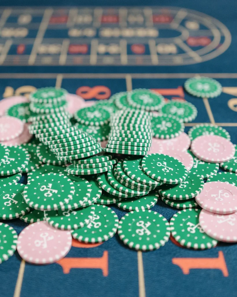 Green and pink gaming chips on a roulette betting table