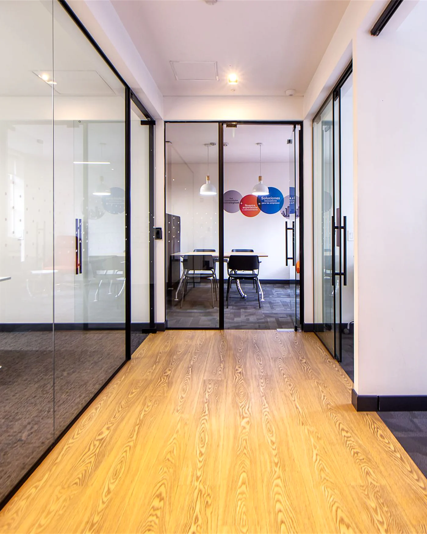 A glass-walled corridor leading to a meeting room