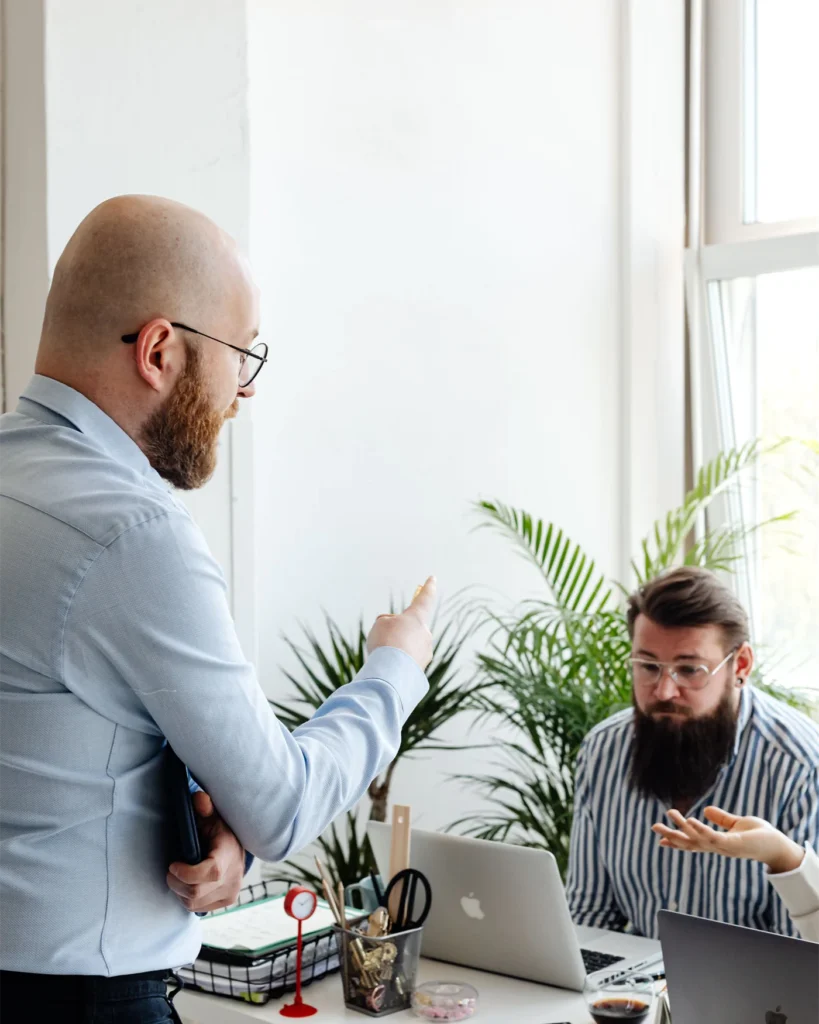 Two colleagues discussing a project in a bright office