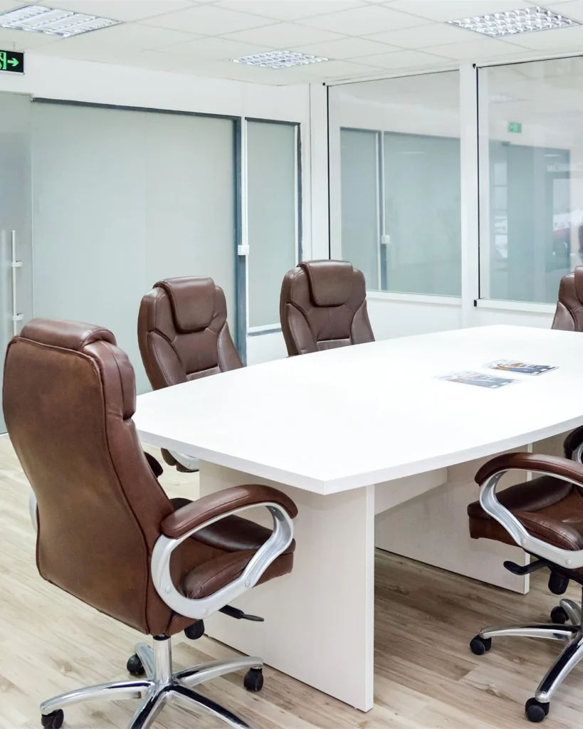 A neutral meeting room with a long table and chairs