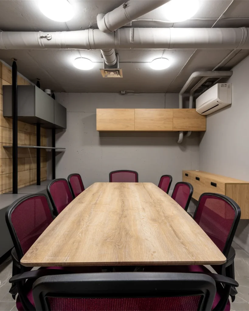 A meeting room with a long wooden table and chairs