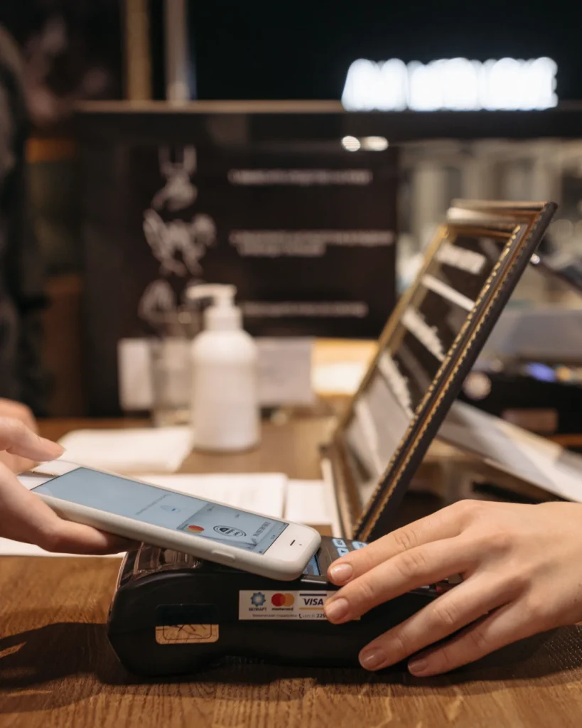 A customer holding a smartphone over a card payment terminal