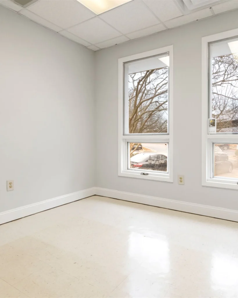 A vacant commercial room with natural daylight from two windows