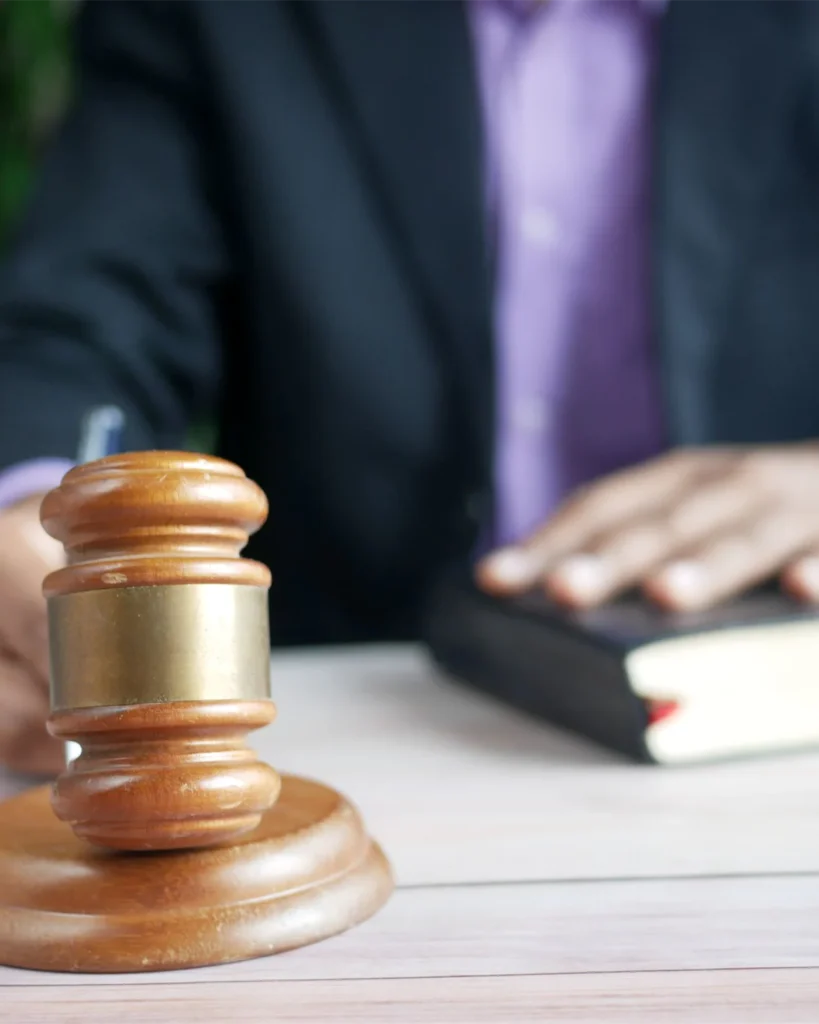 A wooden gavel resting beside a legal book