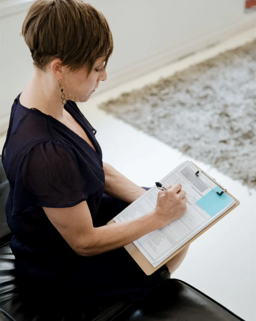 A case worker completing notes on a clipboard