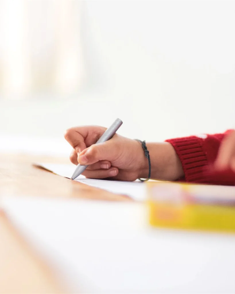 A child drawing with crayons at a table