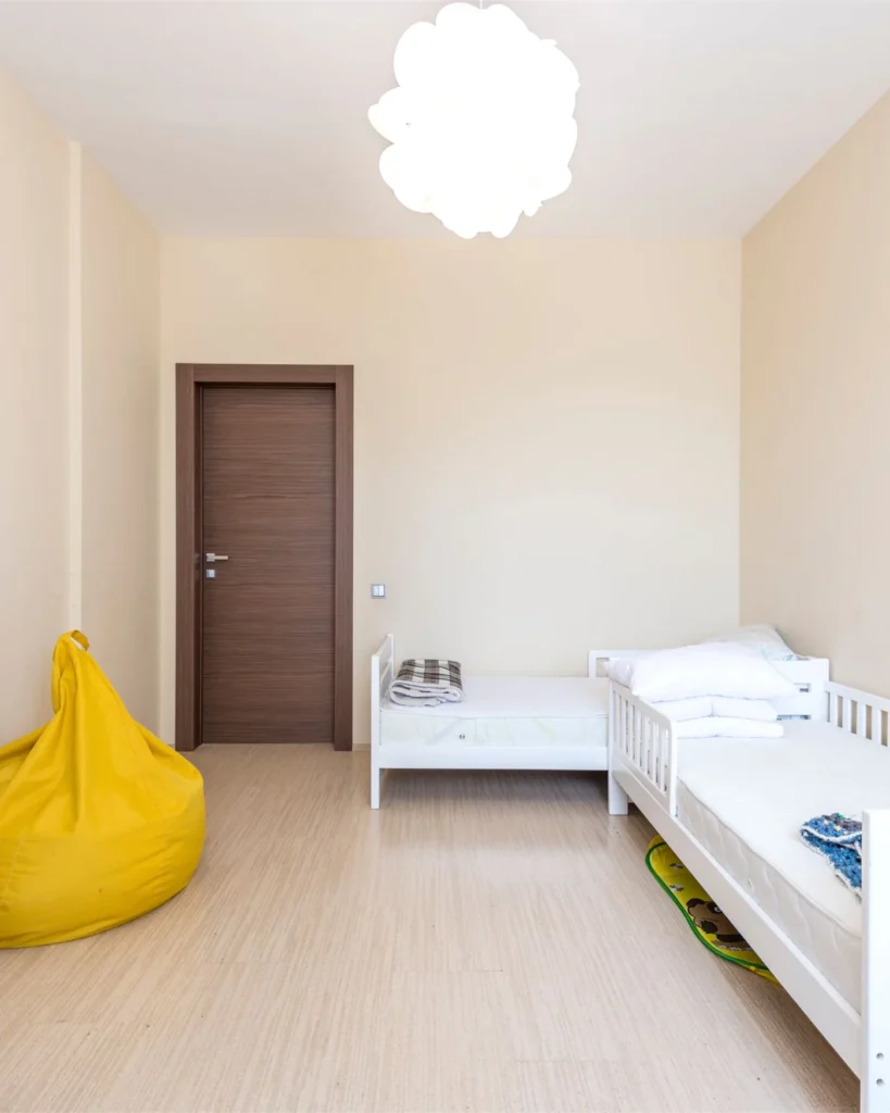 A bright child bedroom with a single bed and wooden floor